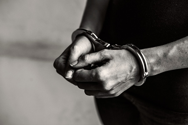 Hands in handcuffs black and white