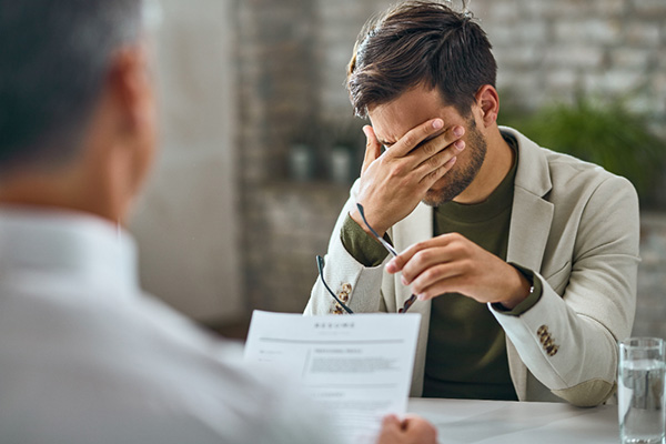 Man in a meeting with head in his hands