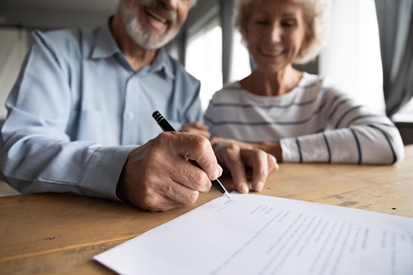 Elderly couple signing a legal document