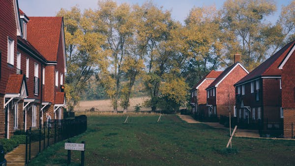 Red brick houses with field behind - Photo by Ryan Collis from Pexels